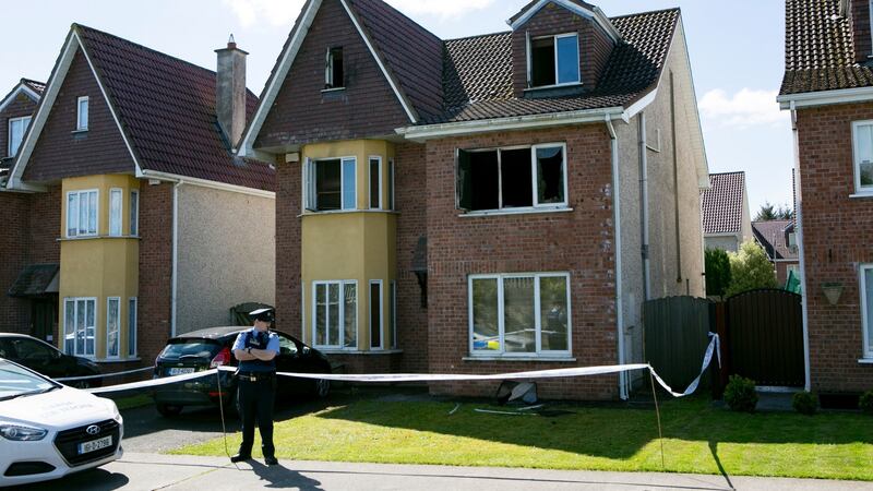 A Garda stands outside a house where Grace McDermott died in a  fire in Riverbank, Annacotty, Co Limerick. Photograph: Brian Gavin Press 22