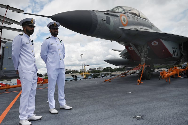 Indian Navy officers stand next to a Mig 29 fighter jet on the deck of the Indian aircraft carrier INS Vikrant. Photograph: Arun Sankar/AFP/Getty