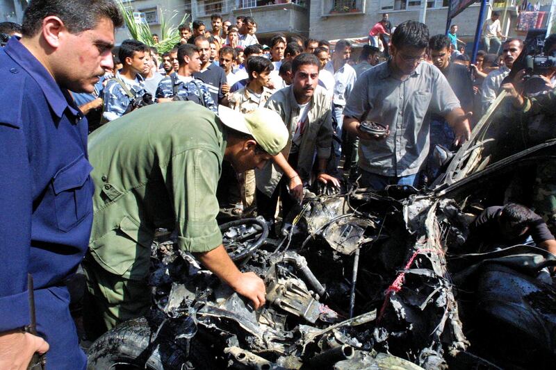Palestinians inspect the wreckage of Mohammed Deif's car, after it was fired on by Israeli helicopter missiles in September 2002 in Gaza City. Photograph: Abid Katib/Getty Images