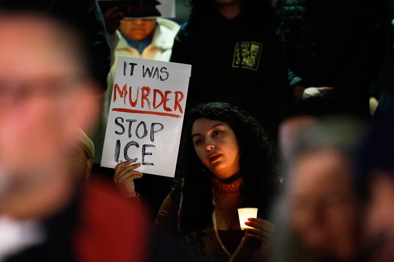 A demonstrator‌ holds a sign during a candlelight vigil during a protest in response to⁣ the fatal shooting of 37-year-old Alex Pretti in Minneapolis (Photo⁤ by Caroline ⁢Brehman/AP)
