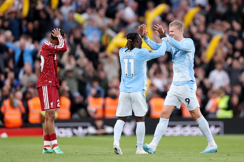 Jeremy Doku and Erling Haaland celebrate Manchester City's third goal at Anfield. Photograph: Alex Pantling/Getty Images