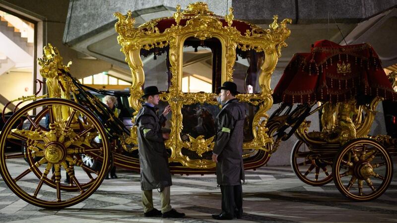 Members of the coach team discuss procedures as they stand next to the state coach, believed to be oldest ceremonial vehicle in regular use in the world. Photograph:  Leon Neal/Getty