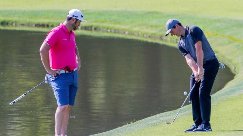 Rahm watches on as McIlroy plays a pitch at the 11th. Photo: Erik S Lesser/EPA