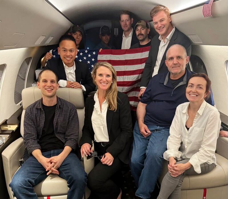 Evan Gershkovich (left), Alsu Kurmasheva (right) and Paul Whelan (second from right) and others aboard a plane following their release from Russian captivity. Photograph: White House via AP