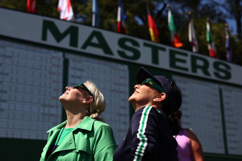 Visitors look on during the solar eclipse during a practice round prior to the Masters Tournament at Augusta National Golf Club in Augusta, Georgia. Photograph: Maddie Meyer/Getty Images