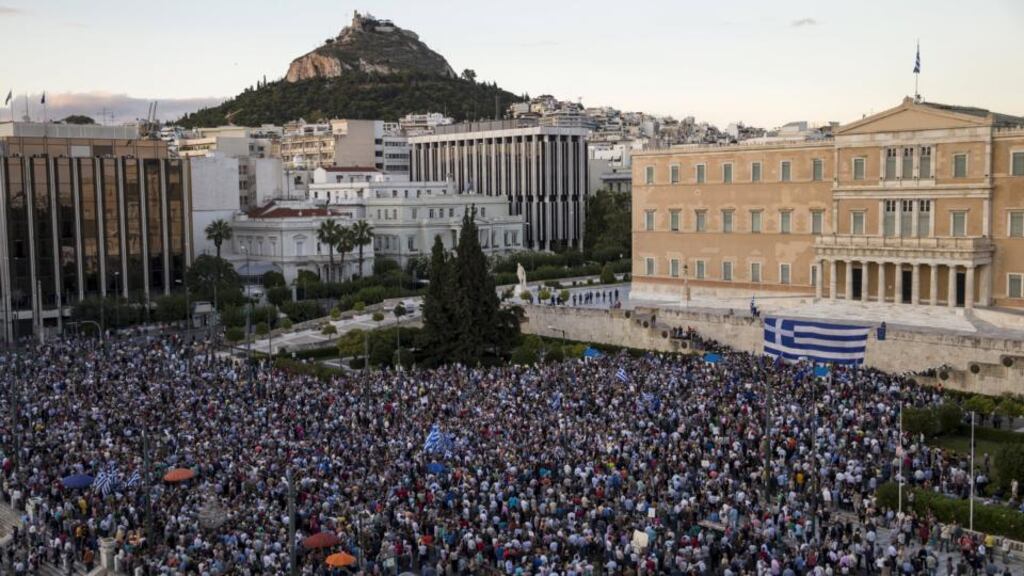 Protesters attend a rally in front of the parliament building, calling on the government to clinch a deal and secure Greece’s future in the euro zone on Monday. Photograph: Reuters