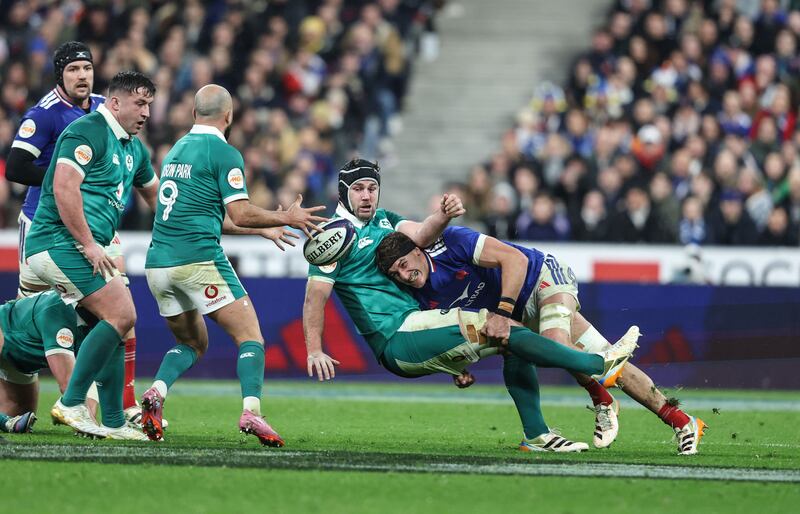 L'Irlandais Caelan Doris passe à Jamison Gibson-Park alors qu'il est abordé par le Français Oscar Jegou. Photographie : Inpho