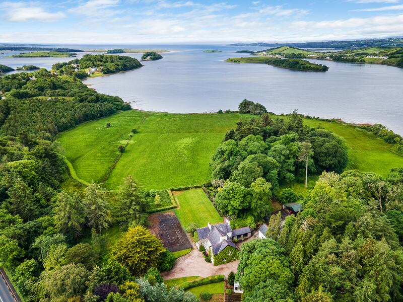 Aerial view of house showing extensive grounds and shore frontage