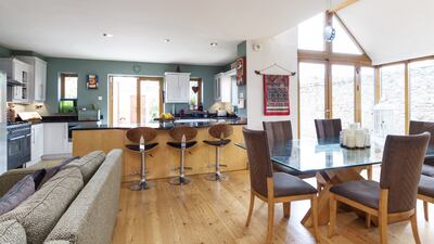 The open-plan living area has  kitchen to the front, a seating area with a solid fuel stove, and space for a large dining table