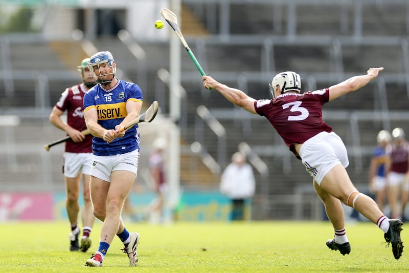 Tipperary's Jason Forde scores a point despite Daithí Burke of Galway. Photograph: Laszlo Geczo/Inpho