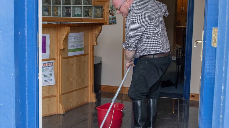 Sean Bonner clearing out flood water  from the Alzhemiers Society charity shop in Donegal Town. Photograph: North West Newspix