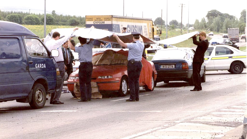 Gardaí placing a cover over Veronica Guerin’s car at the scene of the fatal shooting in June  1996.  Photograph: Pat Langan
