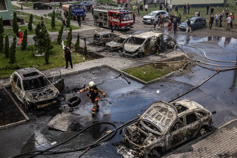 Ukrainian firefighters and rescue personnel at the site of a Russian bombing in Kharkiv, Ukraine. Photograph: David Guttenfelder/The New York Times
                      