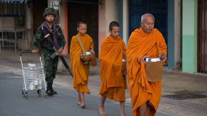 Buddhist monks collecting alms on their morning rounds are protected by armed Thai soldiers  in Pattani. Monks, teachers and other seen as symbols of the Thai state have been the targets of insurgents since 2004. Photograph: Jason South/Fairfax Media/Getty Images