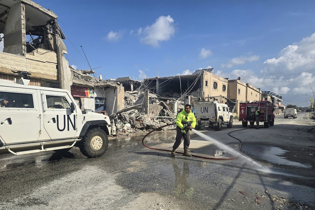 United Nations peacekeepers drive past firefighters clearing the road at the site of an Israeli airstrike in the area of Naqura in southern Lebanon. Photograph: Kawnat Haju/AFP/Getty Images