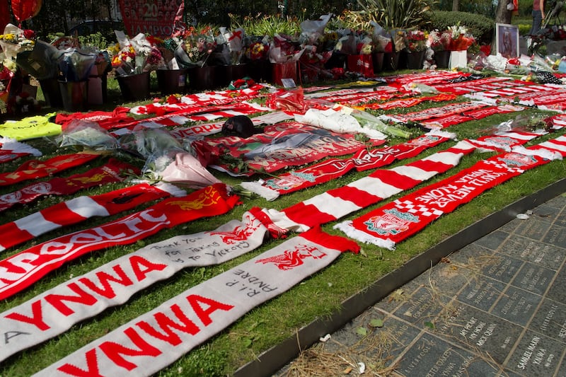 Liverpool scarves are seen beside flowers left at a memorial set up close to Anfield. Photograph: Paul Barker/AFP via Getty