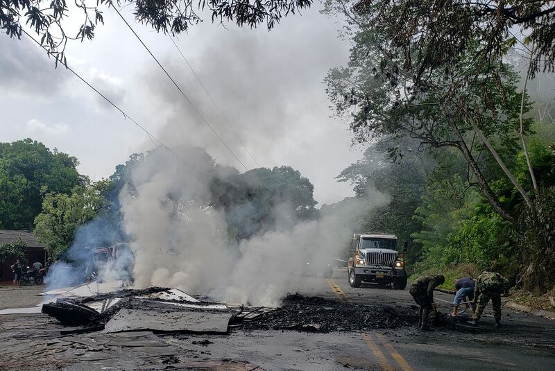 Colombian soldiers remove debris from truck burned by the Clan del Golfo in Taraza, Cauca, Colombia, in March. Photograph: Eder Narvaez /AFP via Getty Images
