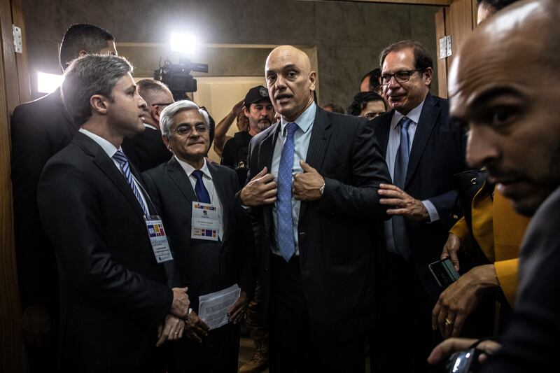 Alexandre de Moraes, center, a supreme court justice who is overseeing most of the investigations into former Brazilian resident Jair Bolsonaro, in Brasilia on October 2nd, 2022. Photograph: Dado Galdieri/The New York Times
                                            