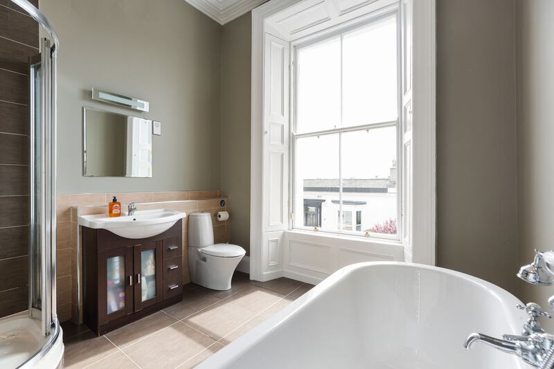 The en suite has a roll-top bath with claw-and-ball feet and a step-in shower cubicle