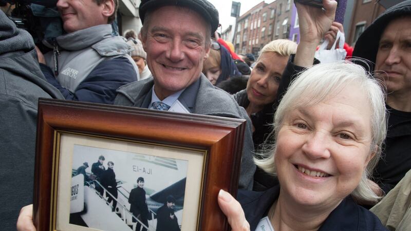 Members of Beatles Ireland, Pete Brennan and Pat Moore, hold up a  picture of the Beatles arriving into Dublin for their concerts. Photograph:  Colm Mahady /Fennells