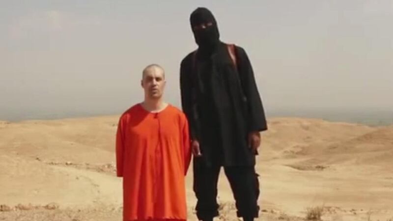 The Islamic State video showing Jame’s Foley’s murder is titled ‘A Message to America’ and shows the journalist on his knees, head shaven and hands tied behind his back, in an orange jumpsuit like those worn by the Muslim prisoners of Guantánamo. A hooded Islamic State militant, dressed in black, stands beside him in the desert, wielding a knife. Photograph: AP Photo