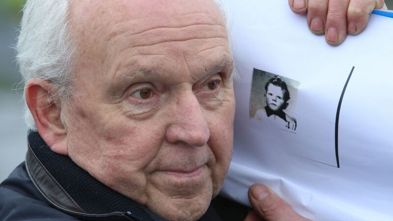 Survivor PJ Haverty holding a copy of his passport picture for his adoption in the USA, when he was four years old. Photograph: Joe O’Shaughnessy
