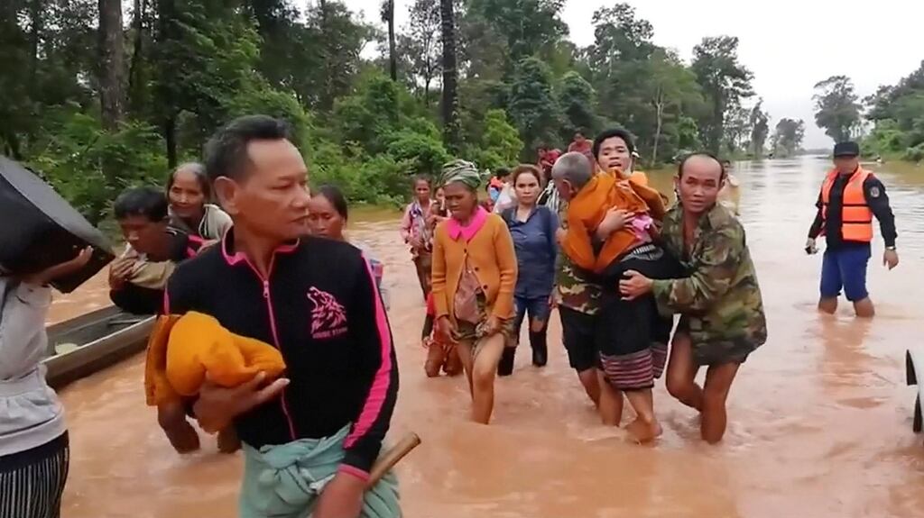 People walk through flooded area after being brought to safety by boat in Sanam Xay district, Attapeu Province, Laos. Photograph: Attapeu Today/Reuters