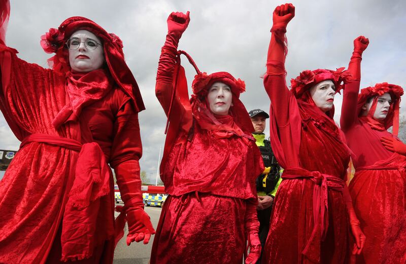 XR Red Rebels blockade the entrance to the air base during the demonstration on April 4th in Lakenheath, England. Protesters have set up a peace camp over Easter to demonstrate at the main gate of the RAF Base that hosts the US Air Force. (Photo by Martin Pope/Getty Images)