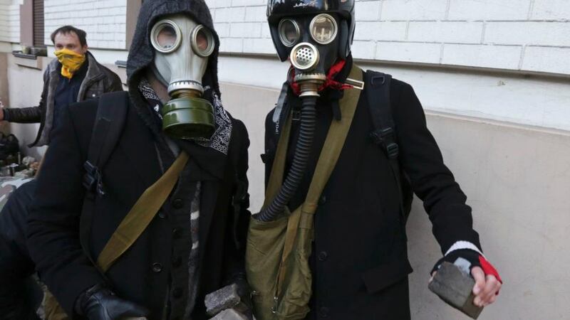 Masked protesters hold stones during clashes with police in Kiev February 18, 2014.  Anti-government protesters clashed violently with police in central Kiev on Tuesday, a day after Moscow moved to cement its influence over Ukraine with $2 billion in cash to shore up the former Soviet state's heavily indebted economy. A parliamentary deputy said on Facebook that three demonstrators had been killed, and Ukrainian television said five protesters had been hurt in the clashes. Neither report could immediately be confirmed.         REUTERS/Konstantin Chernichkin (UKRAINE  - Tags: POLITICS CIVIL UNREST)