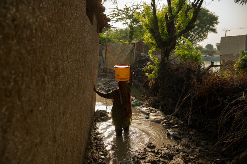 A woman carries water from the only functioning pump in the village of Wado Khosa, Pakistan. Photograph: Kiana Hayeri/The New York Times