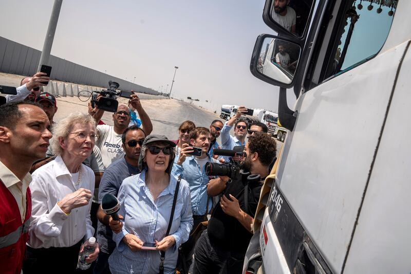 A delegation from The Elders — a global organization advocating for peace — including Mary Robinson and Helen Clark in front of the Rafah border crossing speaking to a truck driver transporting aid. Photograph: Ali Moustafa/ Getty Images
