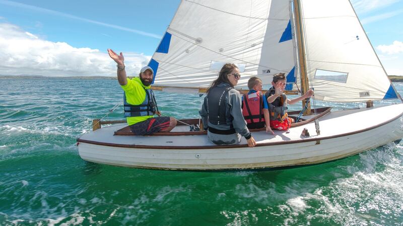 Kevin McCormack on a boat with young sailing students,  off  Heir Island. Photograph: Michael Mac Sweeney/Provision