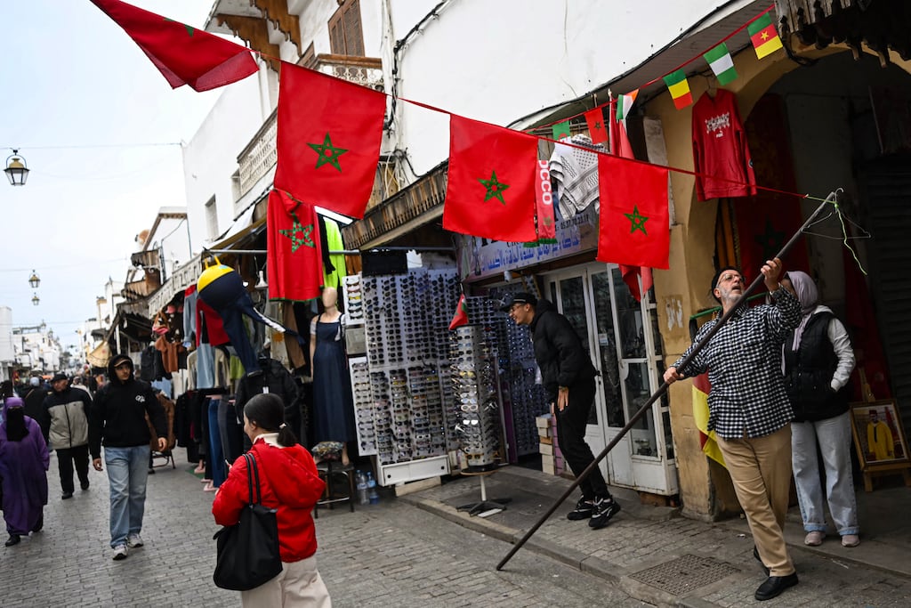 A man installs Moroccan flags in a pedestrian street in Rabat. Photograph: Paul Ellis/AFP via Getty