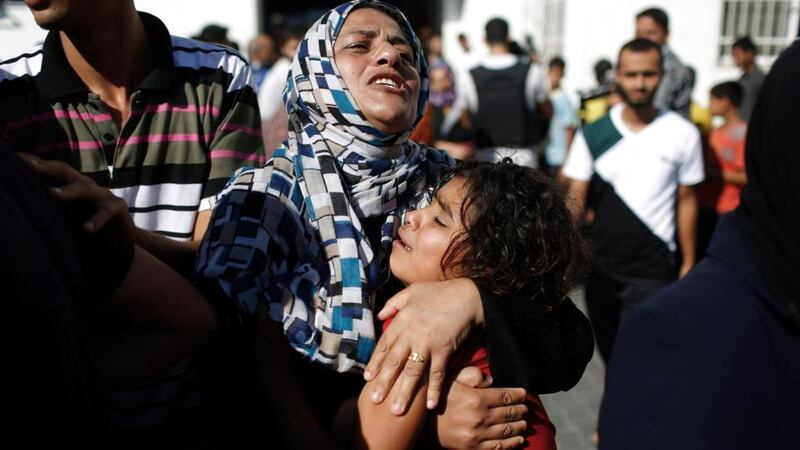 A Palestinian mother comforts her child after what medics said was an Israeli shell that hit a UN-run school sheltering Palestinian refugees, at a hospital in Jabaliya in the northern Gaza Strip. Photograph: Finbarr O’Reilly/Reuters