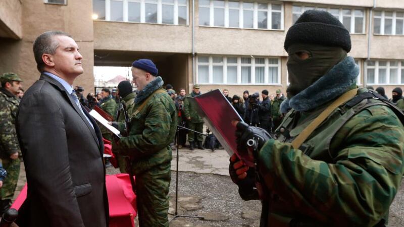 Sergei Aksyonov, Crimea’s pro-Russian prime minister, stands as a member of a pro-Russian self defence unit takes an oath to Crimea government in Simferopol today. Russian forces consolidated their hold on Ukraine’s Crimea peninsula today, taking over a military hospital and a missile base as officials geared up for a referendum on the region’s future. Photograph: Vasily Fedosenko/Reuters