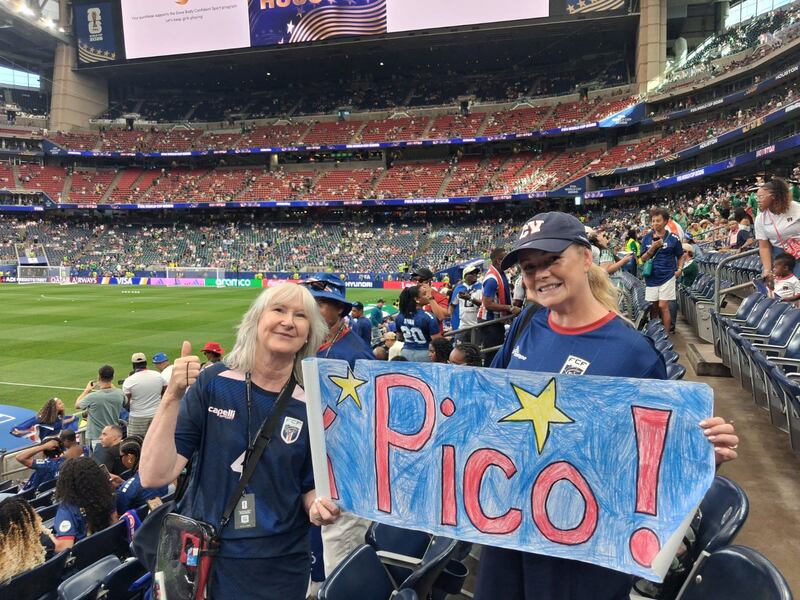 Pico Lopes' mother Judy (left) with his mother-in-law Barbara at an earlier World Cup match holding a sign given to her by pupils at the school she works in