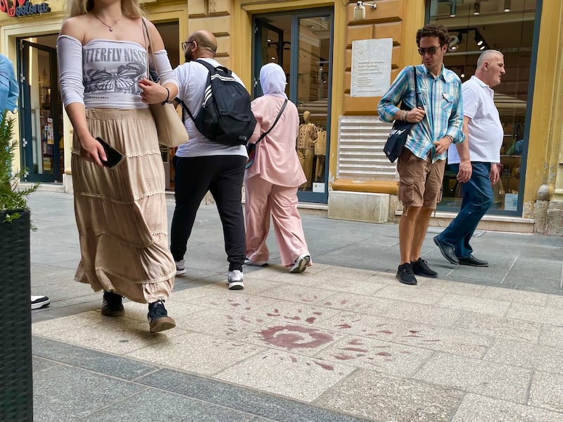 People walk past marks made by a mortar strike in central Sarajevo during the 1992-1995 Bosnian war. Photograph: Daniel McLaughlin