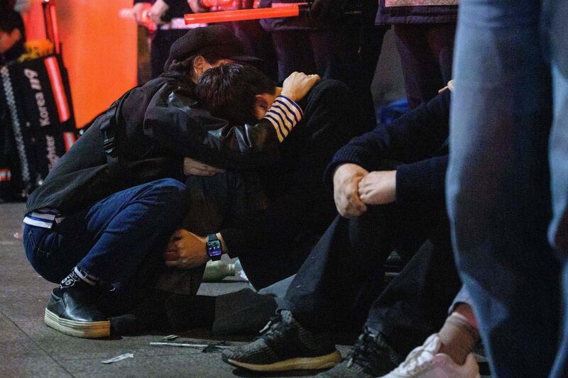 People comfort each other after the stampede at a packed Halloween event in central Seoul. Photograph: Anthony Wallace/AFP