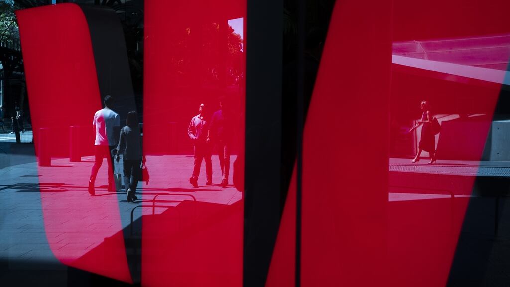 Pedestrians are reflected in a Westpac logo in Sydney. Australia’s financial crime fighting agency has accused the bank of the biggest breach of money laundering laws in the nation’s history. Photograph: Brent Lewin/Bloomberg
