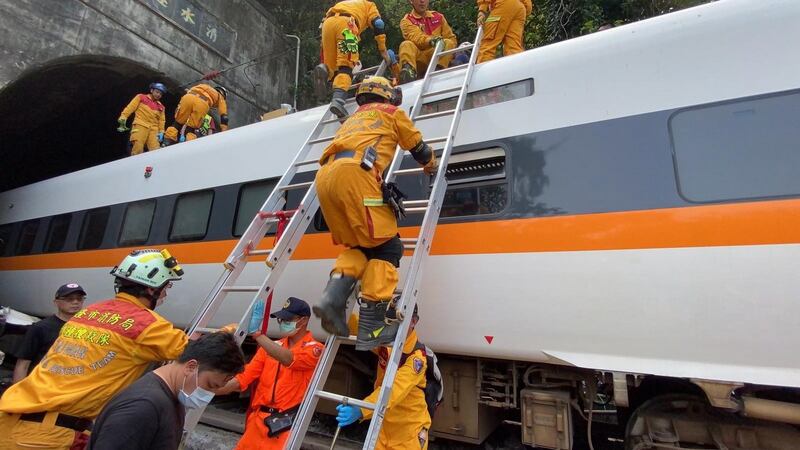 Rescuers working on a train which derailed in a tunnel north of Hualien County, eastern Taiwan. Photograph: Keelung City Fire Department/EPA