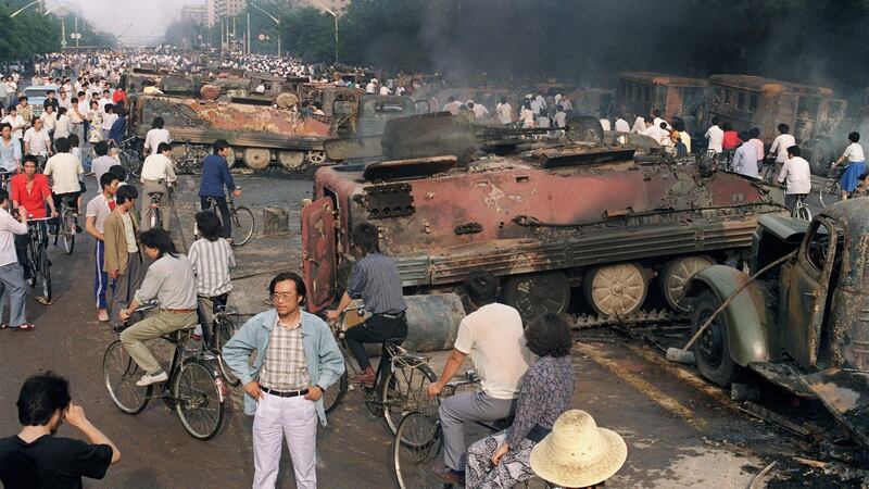 A file image from June 2nd, 1989 showing  anti-government  protesters  near the emains of over 20  armoured personnel carriers burnt out  during clashes with soldiers near Tiananmen Square. Photograph: AFP