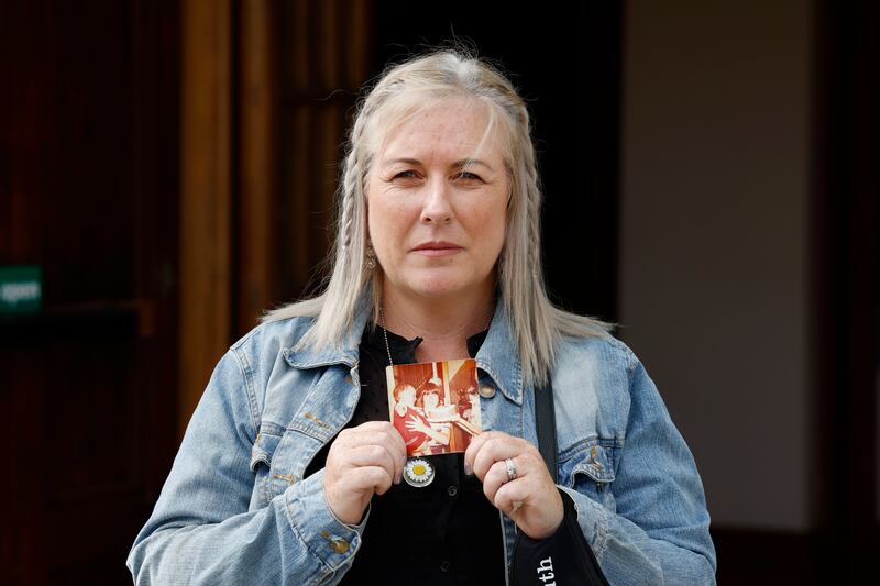 Samantha Curran holding a photograph of her mother Helena Mangan at age 22 (with her in her arms at age one). Photograph: Alan Betson
