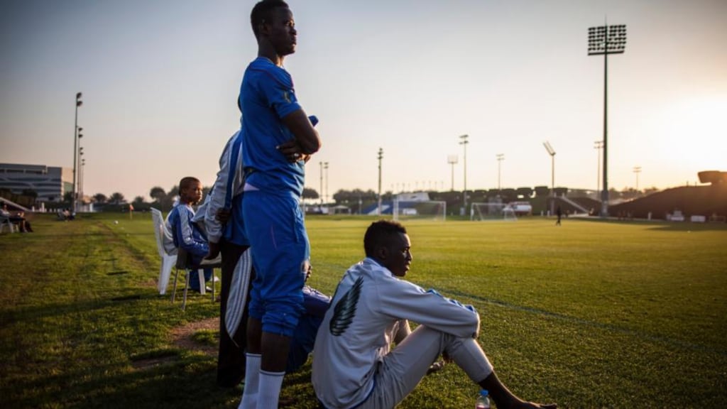 Older African members of the Aspire Football Dreams program watch as younger players played the visiting FC Barcelona youth team, in Doha, Qatar, on January 27th, 2014. Photograph: Bryan Denton/The New York Times
