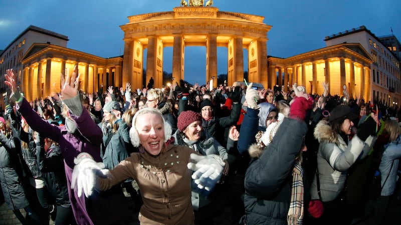 People dance to the theme song of the “One Billion Rising” campaign in front of the Brandenburg Gate in Berlin February 14, 2013. One Billion Rising is a global coordinated campaign aimed to call for an end to violence against women and girls, according to its organisers. REUTERS/Fabrizio Bensch (GERMANY - Tags: SOCIETY)