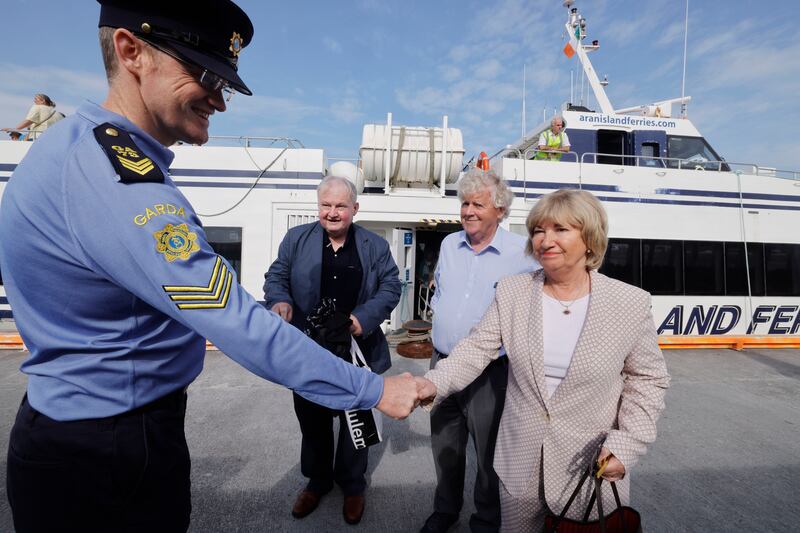Sgt Tomás Concannon greeting Judge Mary Fahy, accompanied by retired doctor Tony Martin and Judge Gerard Furlong, as they arrive on Inis Mór. Photograph: Alan Betson