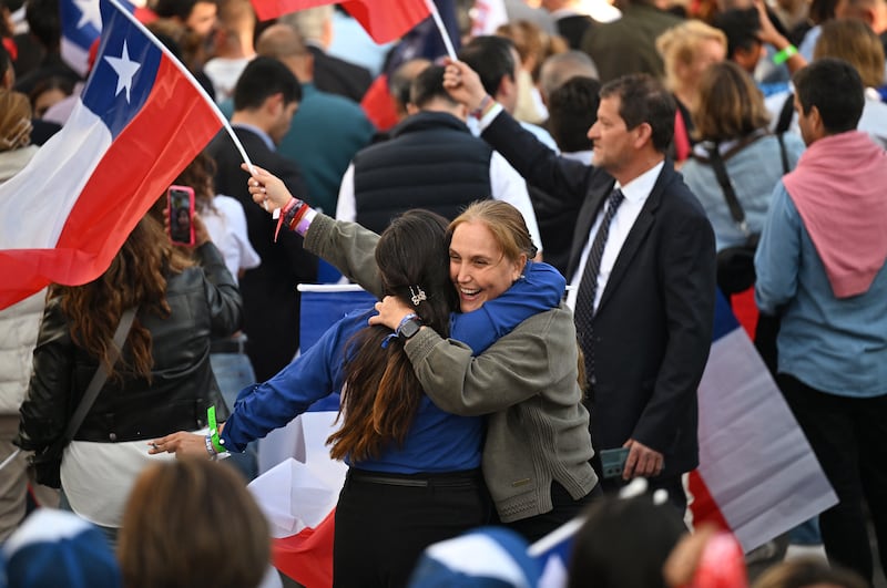 Supporters of Chile's presidential candidate Jose Antonio Kast hug each other following the first results of the presidential runoff election in Santiago. Photograph: Eitan Abramovich/AFP/Getty Images