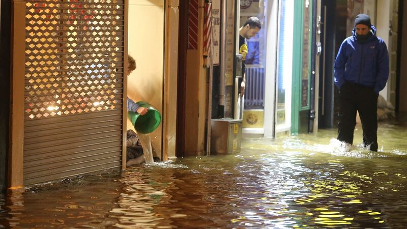 A woman bails out water from a shop as flood waters rise in Cork city on  February 4th, 2014.  File photograph: Niall Carson/PA Wire