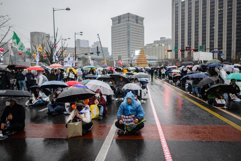Anti-Yoon protesters hold placards that read 'Democracy Won' as they gather at a rally outside Gyeongbokgung Palace in Seoul on April 5th, 2025, to celebrate the removal from office of disgraced ex-president Yoon Suk Yeol. Photograph: ANTHONY WALLACE/AFP via Getty Images         