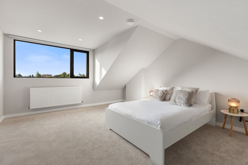 The attic is now a spacious fourth bedroom with ample headroom and a large dormer window looking out to the back