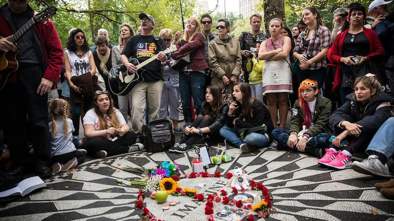 Fans of John Lennon sing songs around the “Imagine” tile mosaic in the Strawberry Fields section of Central Park, New York. Photgraph: Andrew Burton/Getty Images